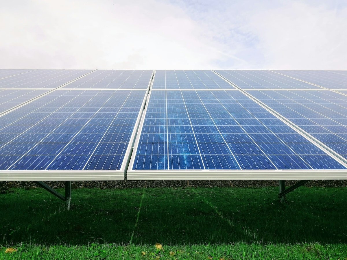 Pannelli fotovoltaici in un campo, simbolo di comunità energetica rinnovabile