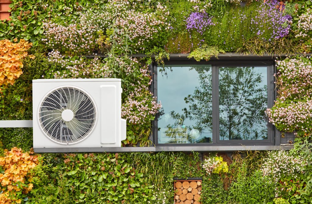 Unità esterna di una pompa di calore su una facciata verde